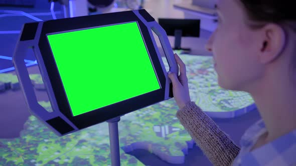 Close Up View: Woman Using Floor Standing Tablet Kiosk with Blank Green Display