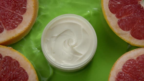 Water Flowing Slow Mo Around Jar of Beauty Cream and Citrus Hydration Slices