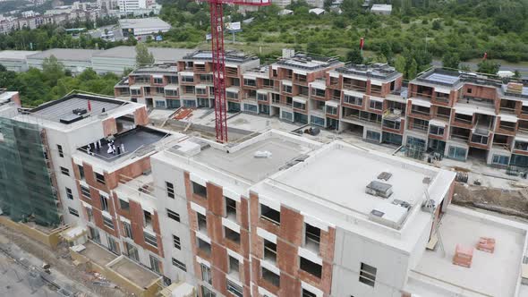 Construction of new apartments with cranes,city outskirts,drone shot. alt