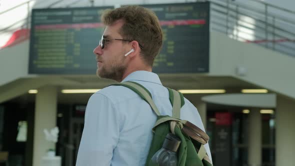 Traveller Is Examining Schedule of Departures and Arrivals in Airport alt
