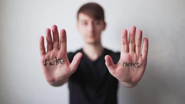 Fake News - Text on Men's Hands. The Concept of Deception in Media and Politics. The Social Problem