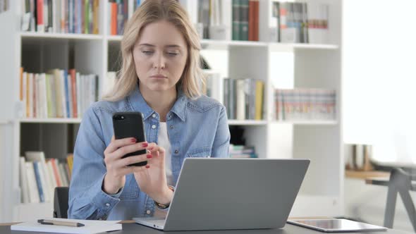 Young Woman Using Smartphone for Online Work alt
