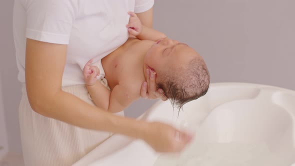 Calm of asian newborn baby bathing in bathtub alt