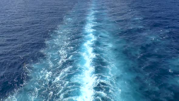 Cruise ship trails in open sea while sailing in calm waters.