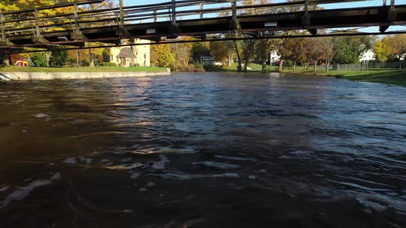 Curwood Castle in Owosso, Michigan with drone shot under bridge to castle. alt