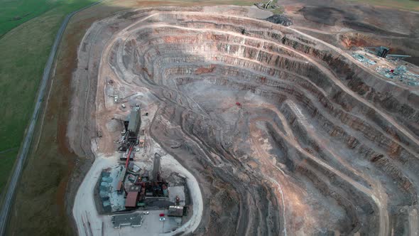 Yorkshire aggregate mining quarry aerial view tilting upwards to countryside scenery alt