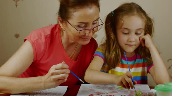 Grandmother Teaches Her Granddaughter How to Paint