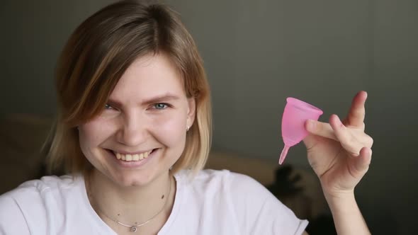 Portrait of Pretty Young Woman Holding Menstrual Cup and Laughing Smiling Iroi alt