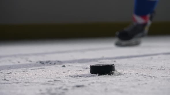 Focus on the Black Hockey Puck Lying on the Ice of the Rink alt
