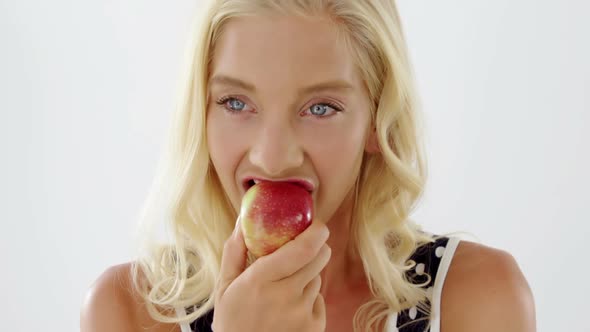 Close-up of beautiful woman eating red apple alt