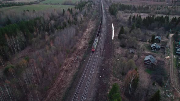 A Train with Empty Open Hoppers Passes By the Village alt
