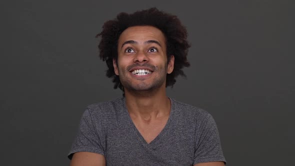 Young African American Male Express Concentration and Then Happiness Isolated Over Charcoal alt