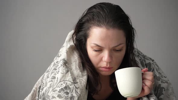 Portrait of Sick Tired Woman Patient with White Cup Sitting on Sofa