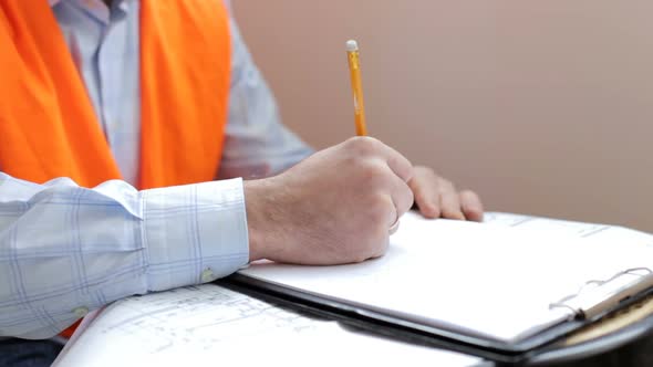 Construction engineer works with blueprints in the office. alt