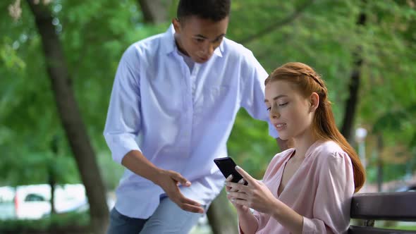 Afro-American Teen Boy Arguing With Girlfriend Chatting Smartphone, Jealousy alt
