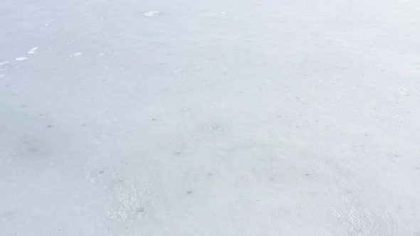 Slow flying over the frozen lake by winter 4K drone video alt