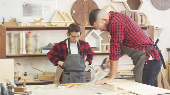 Dad and His Son Are Working in the Workshop alt