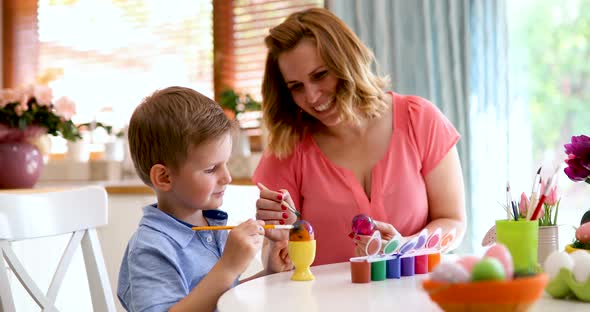 Happy Mother and Son Paint Easter Eggs at Home Together