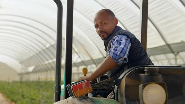 Man sitting on tractor and looking at camera 4k alt