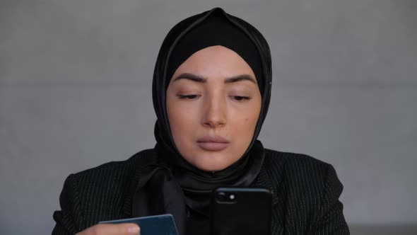 Muslim Consumer Woman in Hijab Shopping Online on Mobile Phone with Credit Card