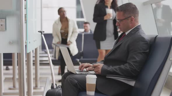Businessman using laptop at airport