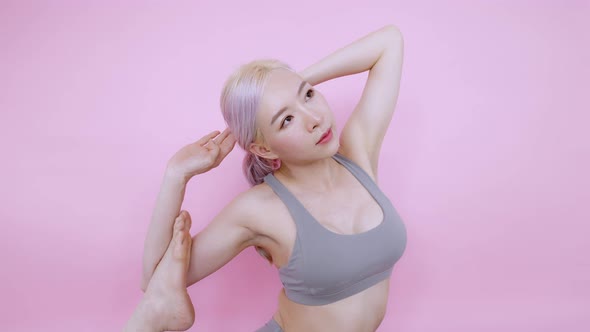 Advance yoga pose of Asian woman exercise workout at home on isolate pink background