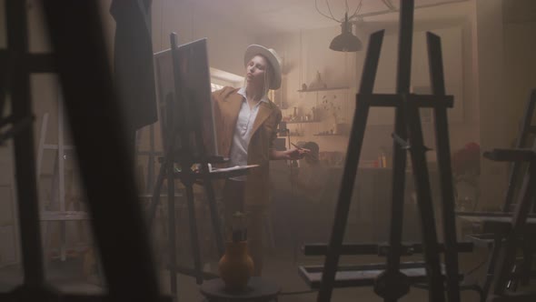 Cheerful Woman Painting On Canvas alt