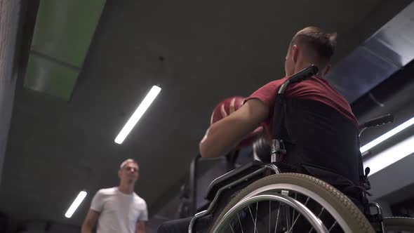 Wheelchair Athlete and His Trainer Working Out with a Medicine Ball