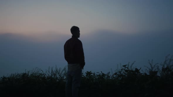 Peaceful Man Enjoying Foggy Landscape in Morning alt