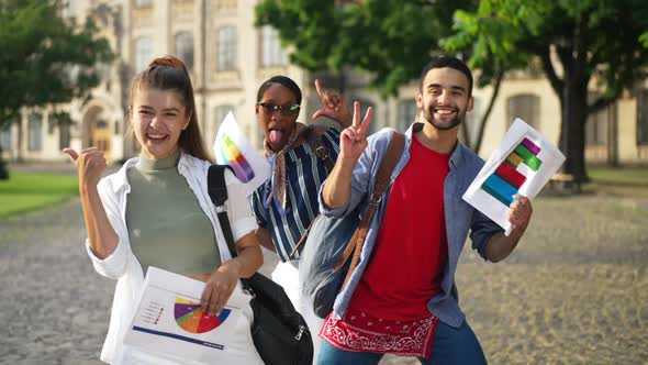 Rack Focus Front to Back Group of Cheerful Young Confident Students Grimacing Gesturing Thumbs Up alt