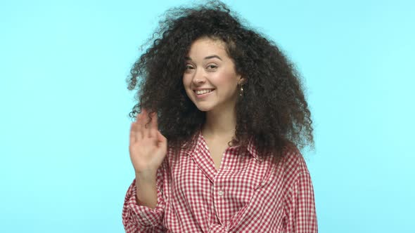 Slow Motion of Beautiful Woman with Curly Hair Saying Hello Waving Raised Hand and Smiling Cute at