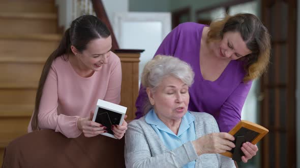Positive Beautiful Caucasian Senior Woman Telling Stories to Daughter and Granddaughter Looking at alt