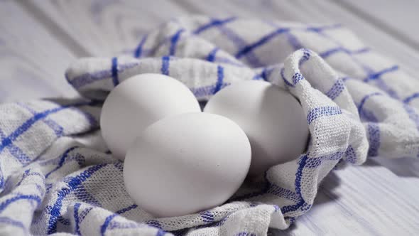 Three Raw Chicken Eggs on the Table Rotating Shot Chicken White Fresh Raw Eggs on a Piece of Cloth alt