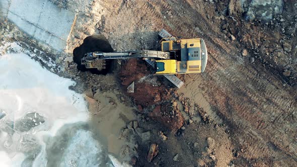 Building, Construction Process. Industrial Vehicle Is Extracting Soil From the Hole in the Ground alt