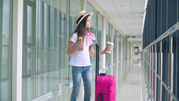 Little Girl Eat Fast Food and Drink Coffee at the Airport While Waiting for the Plane alt