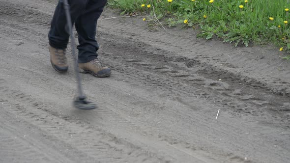 Treasure Hunter Walks on Road with Metal Detector, Scanning Ground of Road