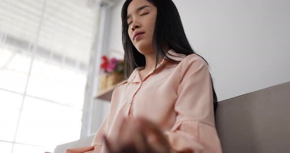 Woman meditating in lotus position sitting on couch alt