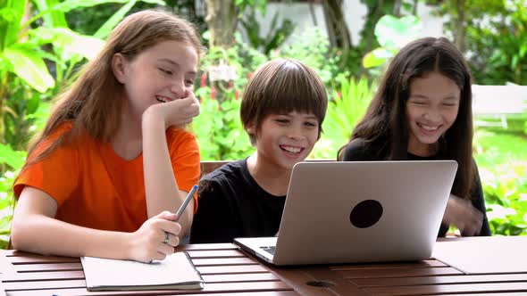 Children, boy and girl, using laptop computer for online learning in garden at home