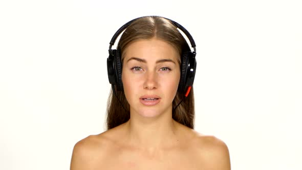 Beautiful Female in Headphones Listening To the Music with Fluttering on the Wind Hair Over White alt