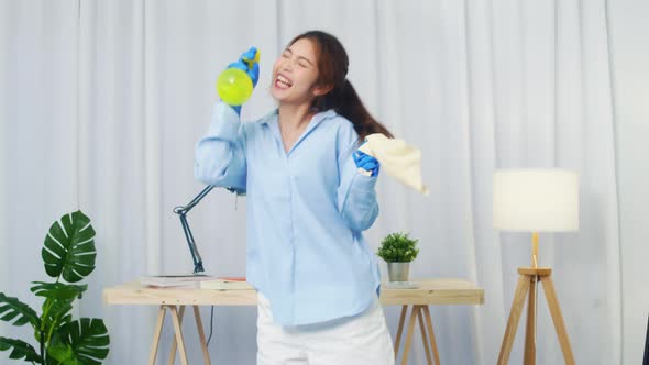 Woman holding spray microphone singing song music in modern living room. alt