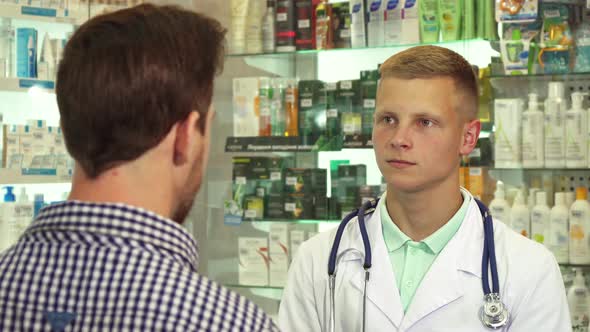 Doctor Talking To Patient with Headache in Drugstore alt