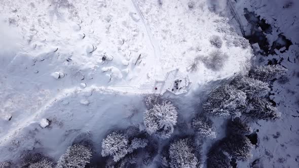 A Broken Gazebo Stands on Snowy Hill in Mountains