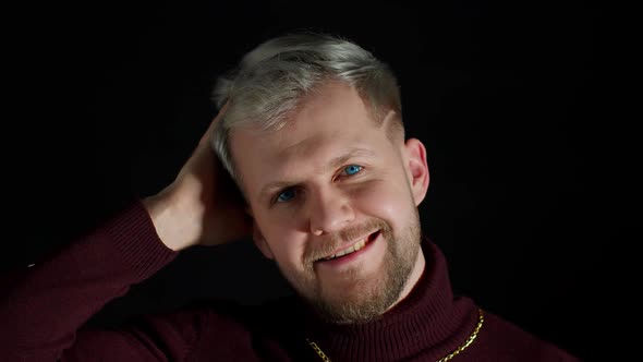 Smiling Cheerful Young Man in Trendy Stylish Clothes Holding Hand Over Head Looking at Camera alt