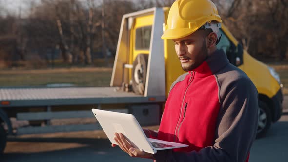 Engineer Wearing Helmet Holding A Laptop And Working Checking His Planned Work alt