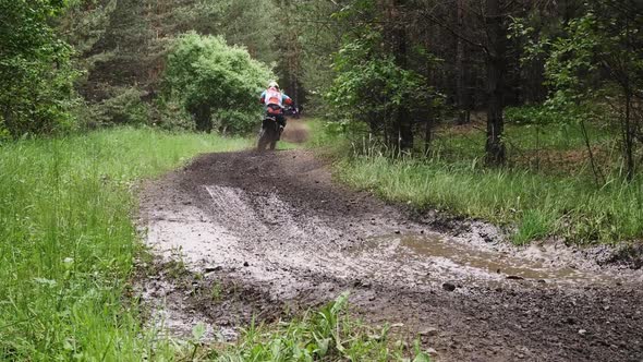 enduro racer riding in puddle of mud and water 