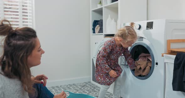 Mom Spends Time With Daughter In Bathroom Laundry Room While Doing