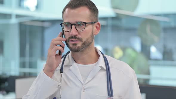 Middle Aged Male Doctor Talking on Smartphone alt