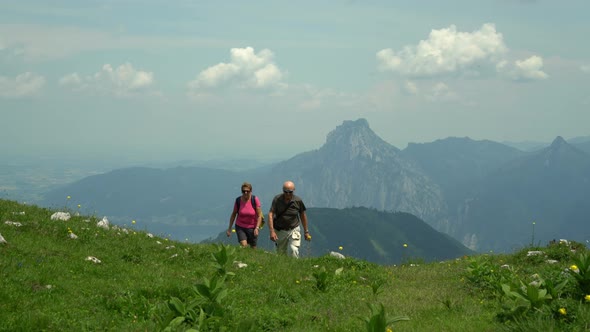 Active Senior Couple Walking up Mountain Pasture
