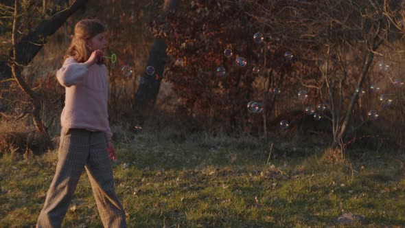 Girl Playing With Bubbles In Field alt