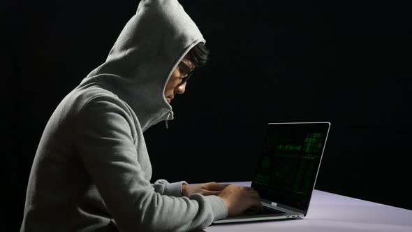 Asian Man Hacking On Computer Laptop alt